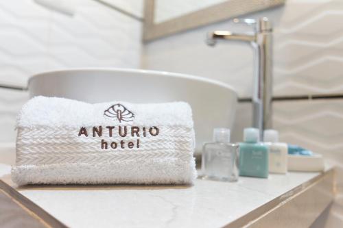 Un lavabo de baño con una toalla sobre un mostrador en Anturio Hotel, en Trujillo
