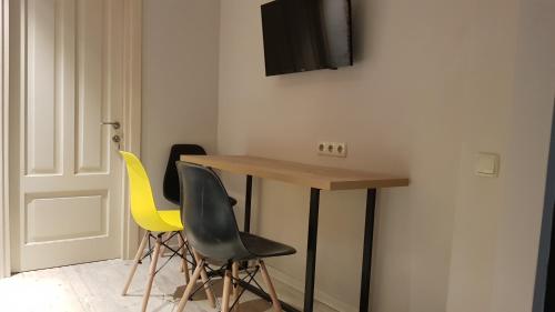 a room with a table and two yellow chairs at D and D hotel in Tbilisi City