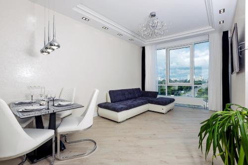 キーウにあるBlack&White Apartment in Smart Plazaのリビングルーム(青いソファ、テーブル付)