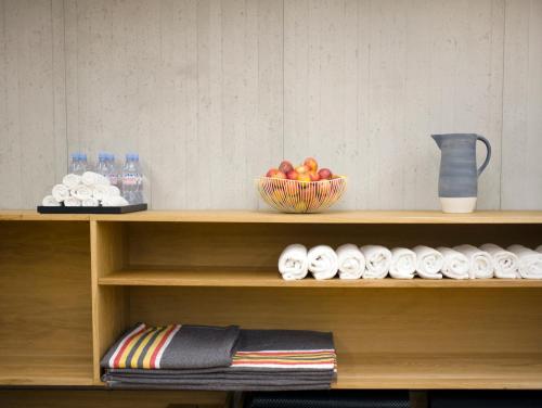 a shelf with a bowl of fruit and a bowl of water at Hôtel National Des Arts et Métiers in Paris