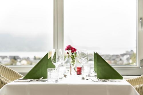 a table with a white table cloth and a vase of flowers at Hollwegers Landhaus - Das Lisl in Sankt Gilgen