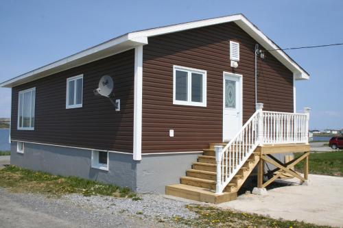 a small house with a staircase on the side of it at Burnt Cape Cabins in Raleigh