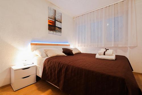 ein Schlafzimmer mit einem großen Bett und einem Nachttisch mit einer Lampe in der Unterkunft Apartment Havana in Zadar