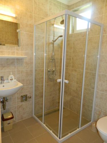 a shower with a glass door in a bathroom at Família-Pelso apartmanház in Zamárdi
