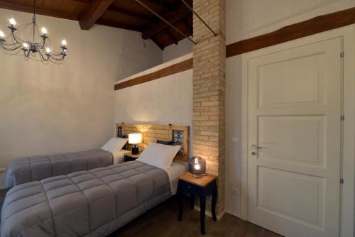 1 dormitorio con 2 camas y puerta en Antico Podere Emilia, en Reggio Emilia