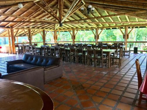uma sala de jantar com mesas e cadeiras num pavilhão em Finca Hotel La Esmeralda Casa 1 em Calarcá