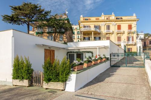 a white house with potted plants on a fence at KaMyHouse Una tranquilla struttura nel verde in Naples