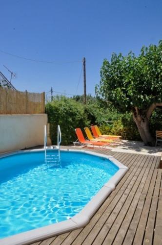 a swimming pool with a water fountain on a wooden deck at Sarris House in Xirokámbion
