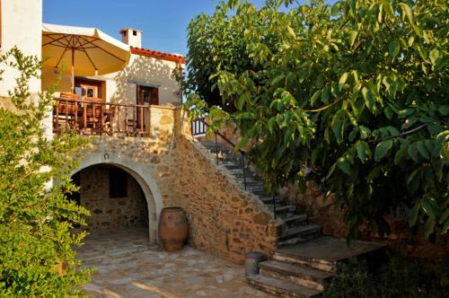 a stone staircase leading to a house with an umbrella at Sarris House in Xirokámbion