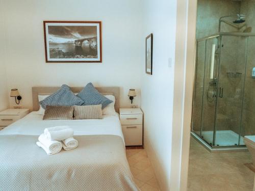 a bedroom with two beds and a glass shower at The Maltese Sun in Sliema