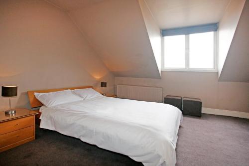 a bedroom with a large white bed and a window at The Red Door in Limerick