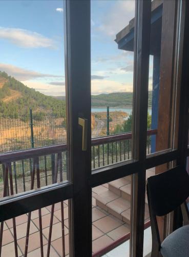 a door to a balcony with a view of the ocean at Mirador Del Río Piedra in Nuévalos