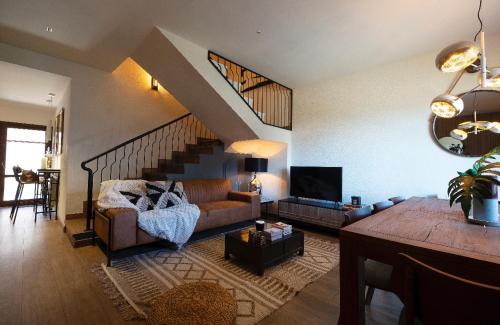 a living room with a couch and a staircase at Mirador Del Río Piedra in Nuévalos