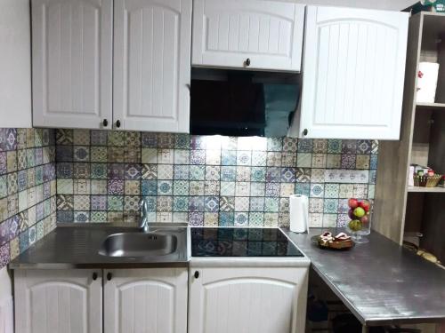 a kitchen with white cabinets and a sink at Отель "Swallow House" in Cherkasy