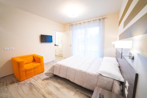 a bedroom with a large bed and a yellow chair at La Casa Di Alice in Rodello