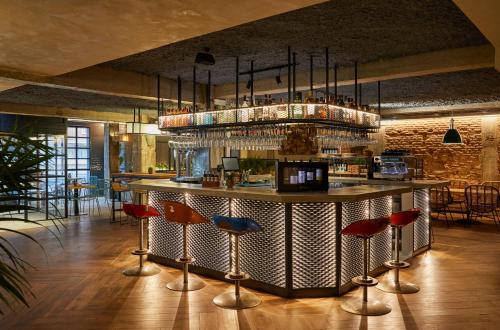 a bar in a restaurant with bar stools at Hotel Indigo Madrid - Princesa by IHG in Madrid