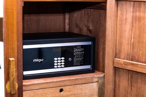 a microwave oven in a wooden cabinet at Macalister Terraces Hotel in George Town