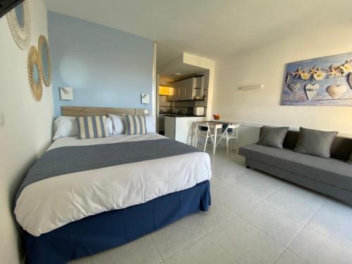 1 dormitorio con 1 cama grande y 1 sofá en MiNERVA, en Benalmádena