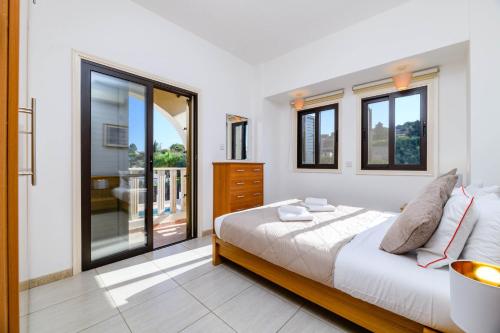 1 dormitorio con 1 cama y balcón en Villa Amaryllis, en Protaras