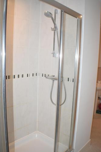 a shower with a glass door in a bathroom at Four Chimneys House in Peterborough
