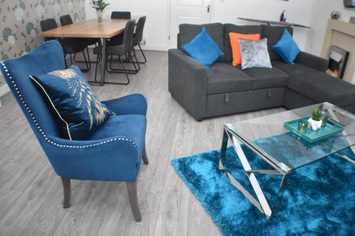 a living room with a couch and a table at Four Chimneys House in Peterborough