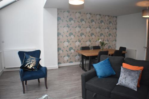a living room with a couch and a table at Four Chimneys House in Peterborough