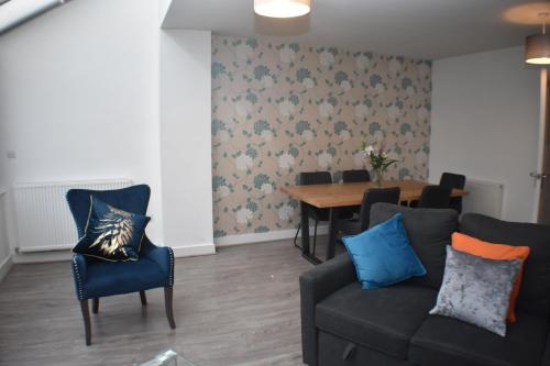 a living room with a couch and a table at Four Chimneys House in Peterborough