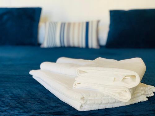 une pile de serviettes blanches assises sur un lit dans l'établissement POSEA - Polignano Sea Suites, à Polignano a Mare