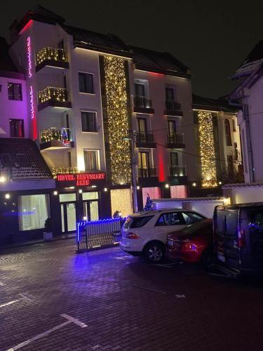 a car parked in front of a building with christmas lights at Aris Hotel Sofia in Sofia