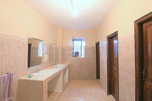 a bathroom with two sinks and a large mirror at Tigmi Tachddirt in Tacheddirt