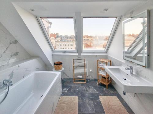 baño con 2 lavabos, bañera y ventanas en Pension Primavera 2, en Viena