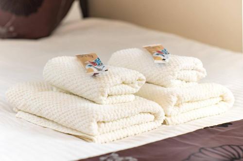 a pile of white towels sitting on a bed at Villa Kamakura in Kamakura