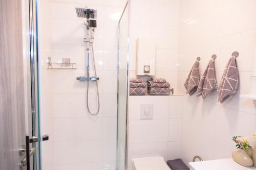 een witte badkamer met een douche en een wastafel bij T&K Apartments near Messe Fair Trade Düsseldorf und Airport 2B in Duisburg