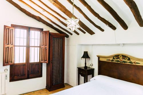 a bedroom with a bed and a wooden ceiling at Cortijo Abril in Priego de Córdoba