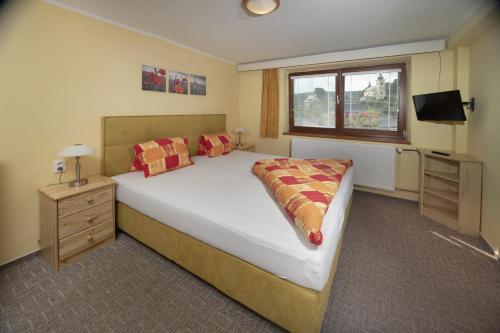 a bedroom with a large white bed and a window at Pension Jana - Wellness in Jilemnice
