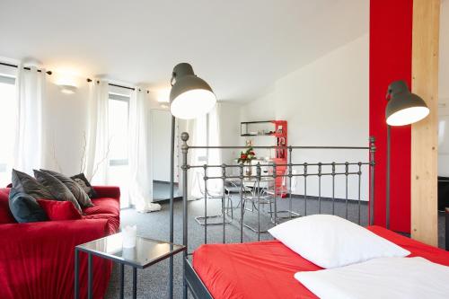 uma sala de estar com um sofá vermelho e uma mesa em Gästehaus am Landgut em Schönwalde