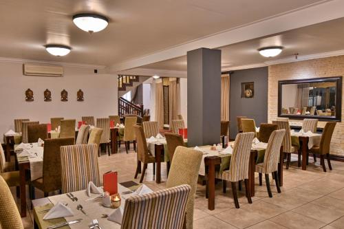a restaurant with tables and chairs in a room at Villa Bali Luxury Guesthouse in Bloemfontein