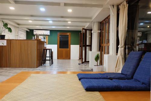 a living room with blue couches and a table at Barn Laos Hostel in Vientiane