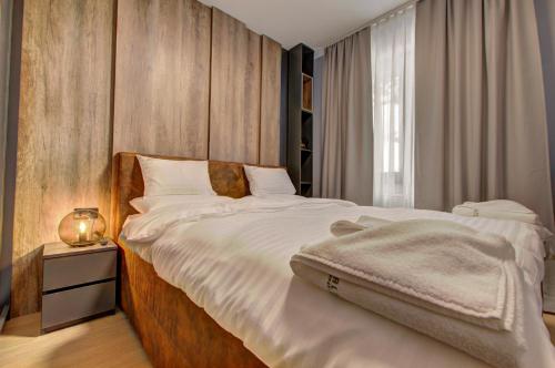 a bedroom with a large white bed and a window at Apartment A1 Lux Alpin in Jahorina