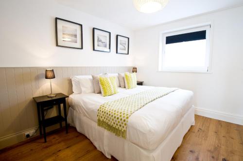 a bedroom with a large white bed and a window at 27 The Terrace in St Ives