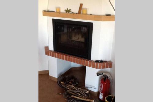 a fireplace with a brick mantle and a fire hydrant at Casa Atlântico in Odeceixe