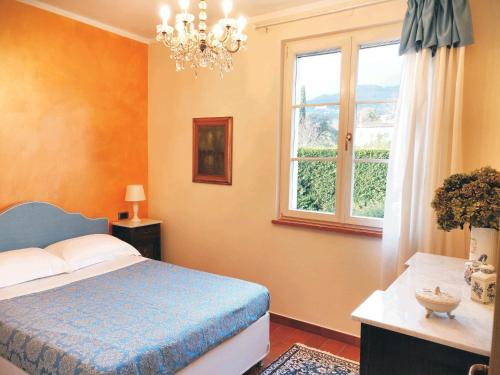 um quarto com uma cama azul e uma janela em Tuscan Villa exclusive use of private pool A/C Wifi Villa Briciola em Capannori