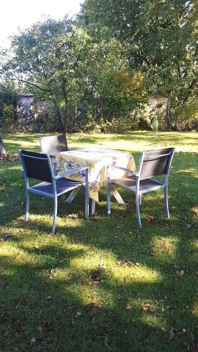 two park benches with a table in the grass at MIRABELLE in Chieulles