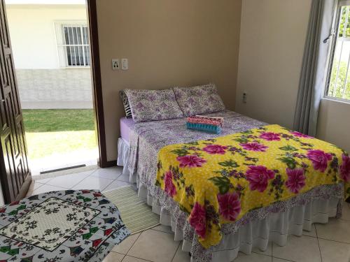 1 dormitorio con 1 cama con edredón de flores en Pousada Mera, en Florianópolis