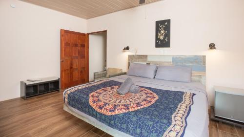 a bedroom with a king sized bed and a tv at Jardín de los Monos in Matapalo