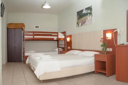 薩索斯的住宿－Vournelis Hotel，一间卧室配有两张床和一张双层床。