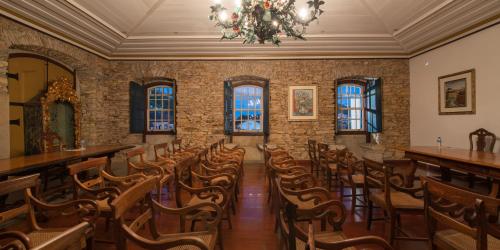 a room with a bunch of chairs and a chandelier at Pousada do Mondego in Ouro Preto