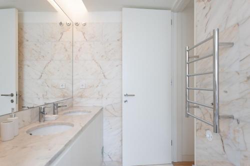 a bathroom with two sinks and a mirror at FLH Chiado Central Flat in Lisbon