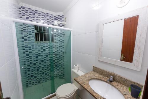 a bathroom with a sink and a glass shower at Apto Térreo - Rio das Ostras in Rio das Ostras