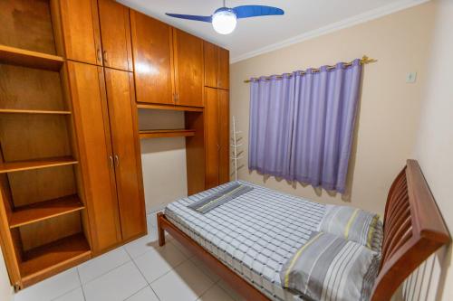 a small bedroom with a bed and wooden cabinets at Apto Térreo - Rio das Ostras in Rio das Ostras